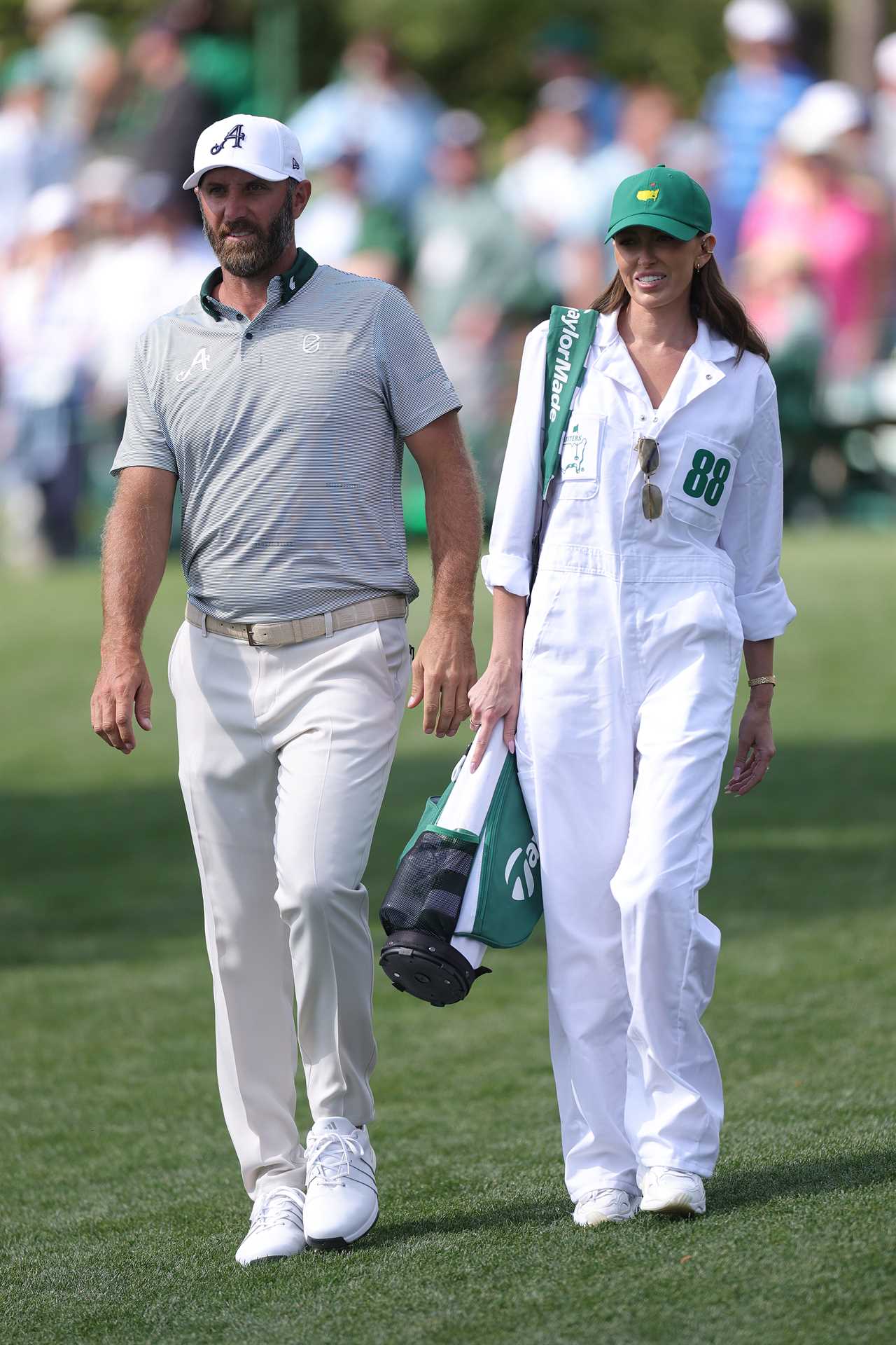 Dustin Johnson and his wife Paulina Gretzky walking at a golf tournament.