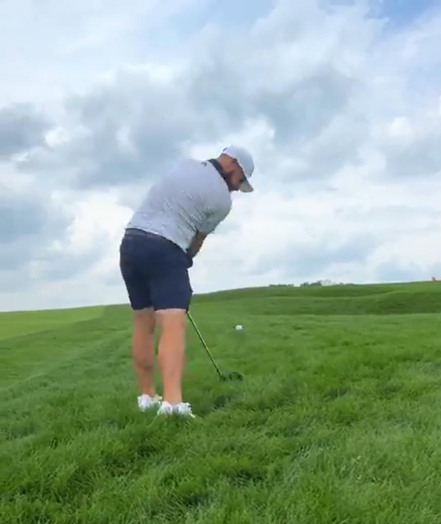 Golfer preparing to hit a golf ball.