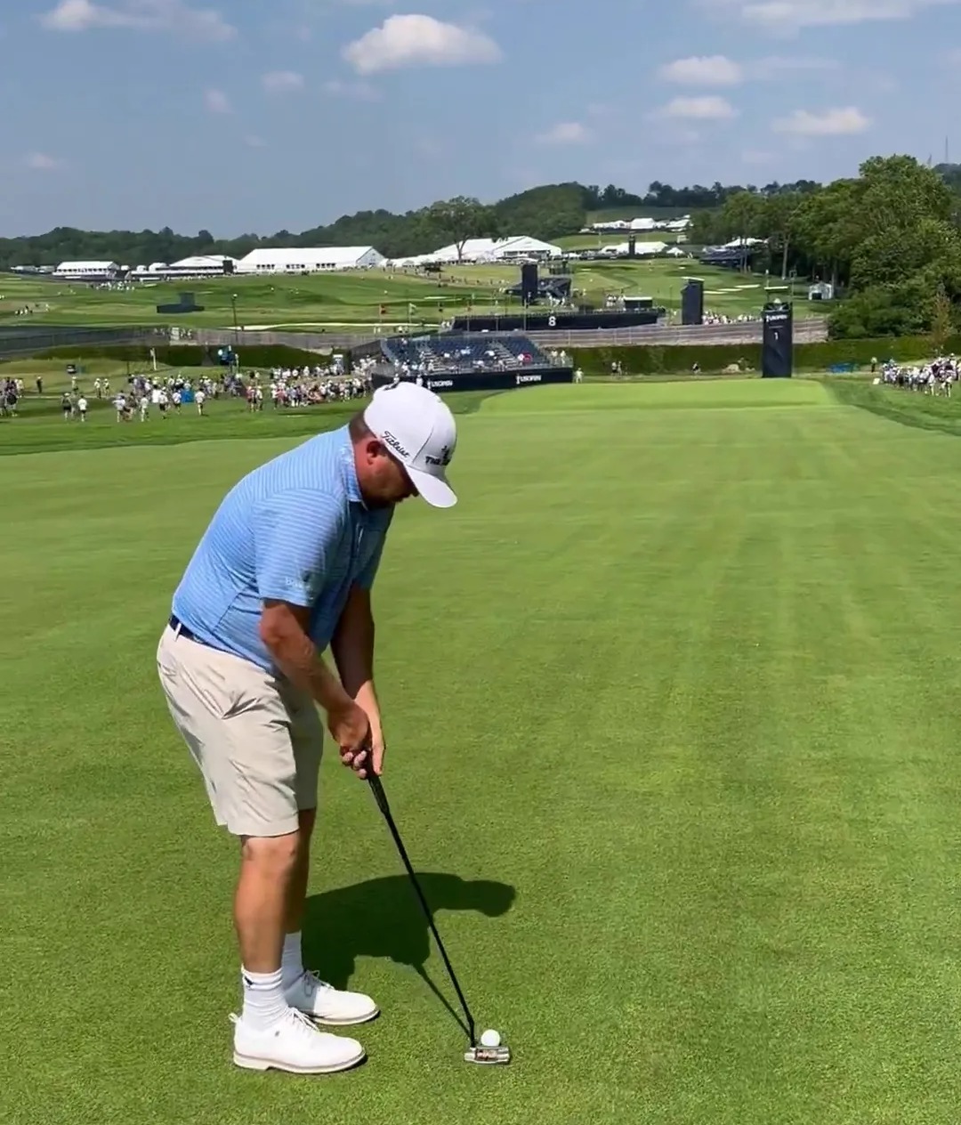 Golfer about to putt on a golf course.