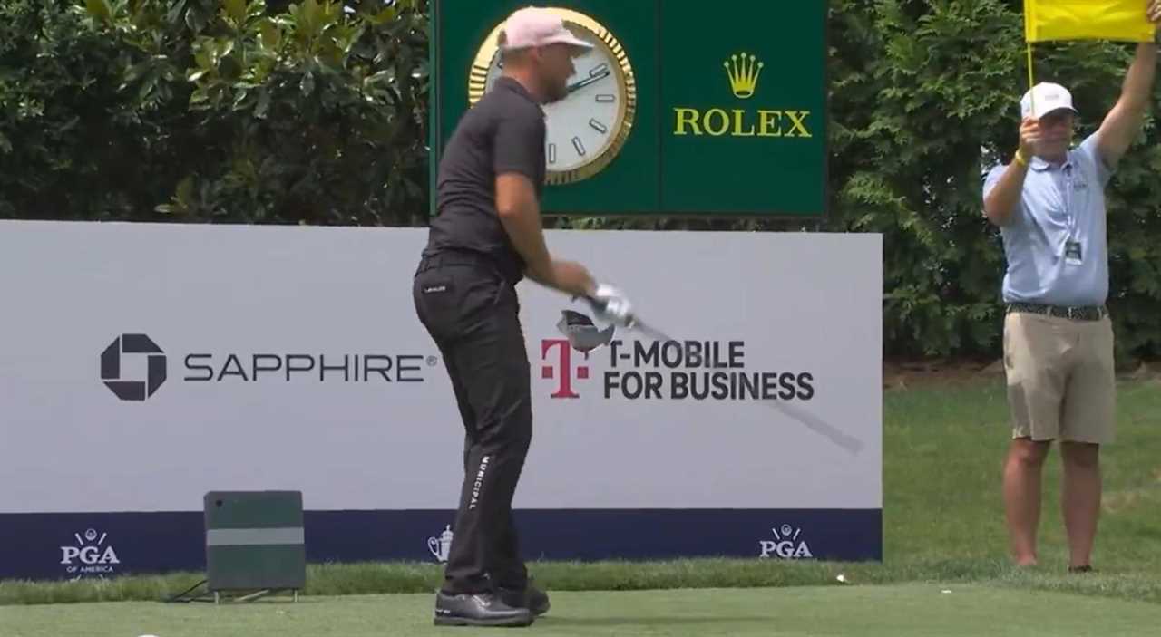 Golfer teeing off on a golf course.