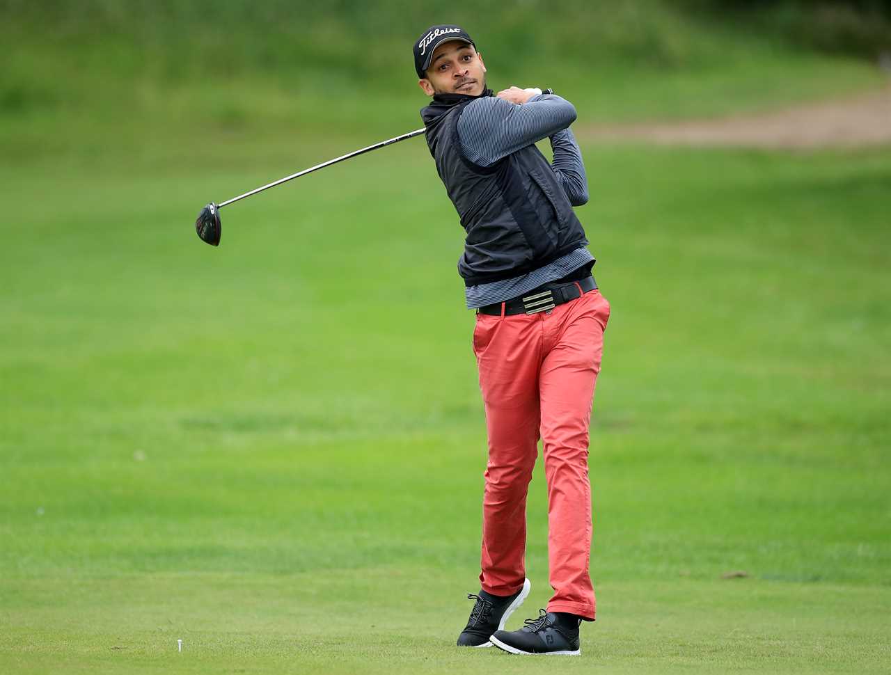 Peter Odemwingie taking a tee shot in a golf tournament.