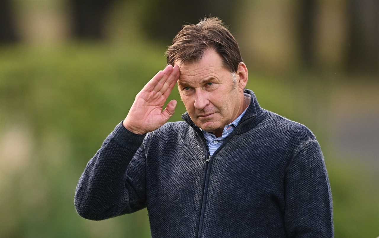 Sir Nick Faldo saluting at a golf tournament.