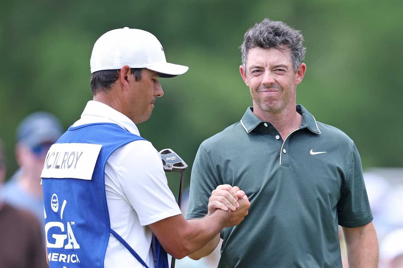 Rory McIlroy shaking hands with his caddie.