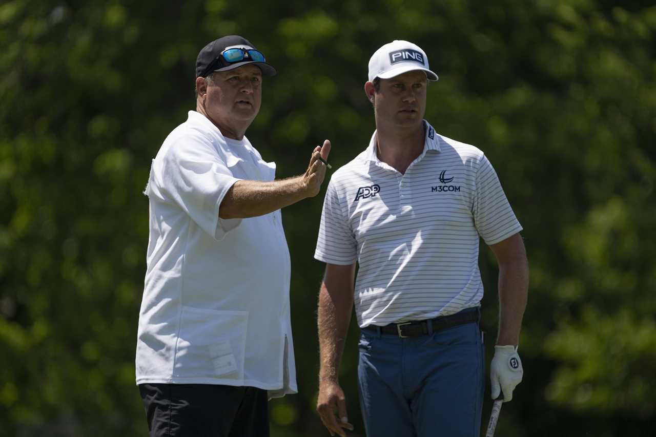 Harris English and his caddie Eric Larson talking on a golf course tee box.