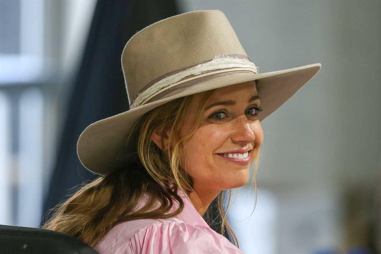 Meredith Scudder, Scottie Scheffler's wife, wearing a hat in a media center.