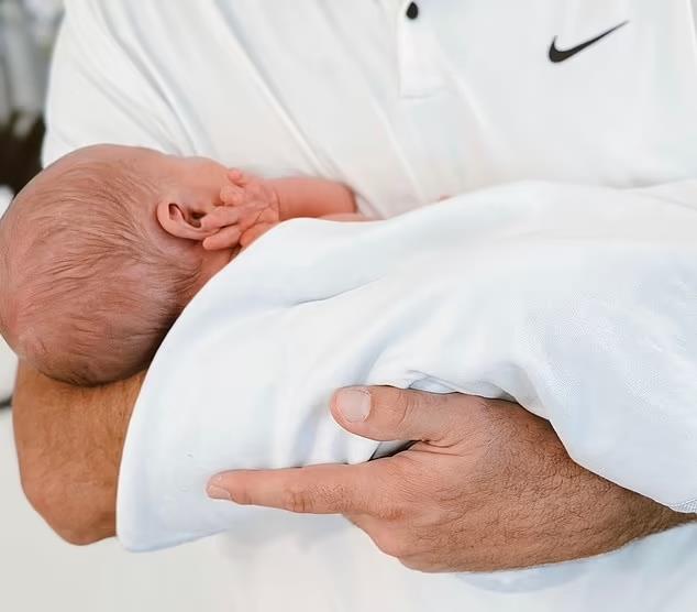 A father holding his newborn baby.