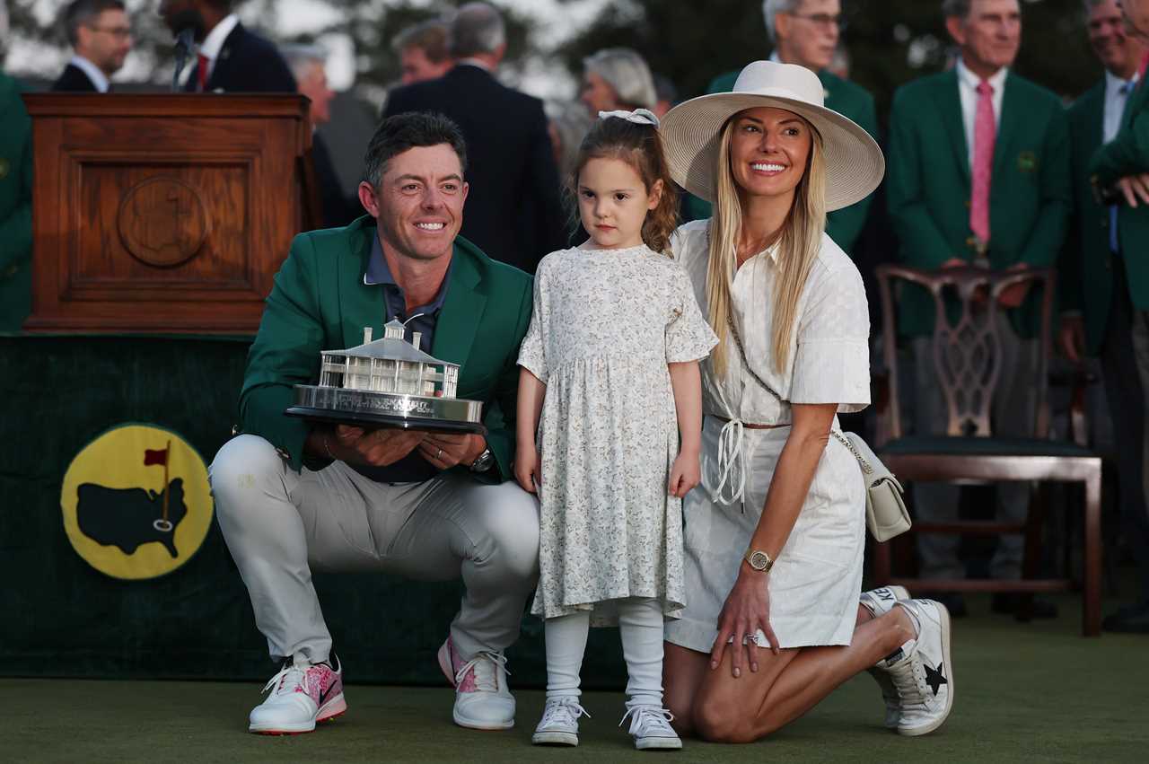 Rory McIlroy with his wife and daughter, holding the Masters trophy.