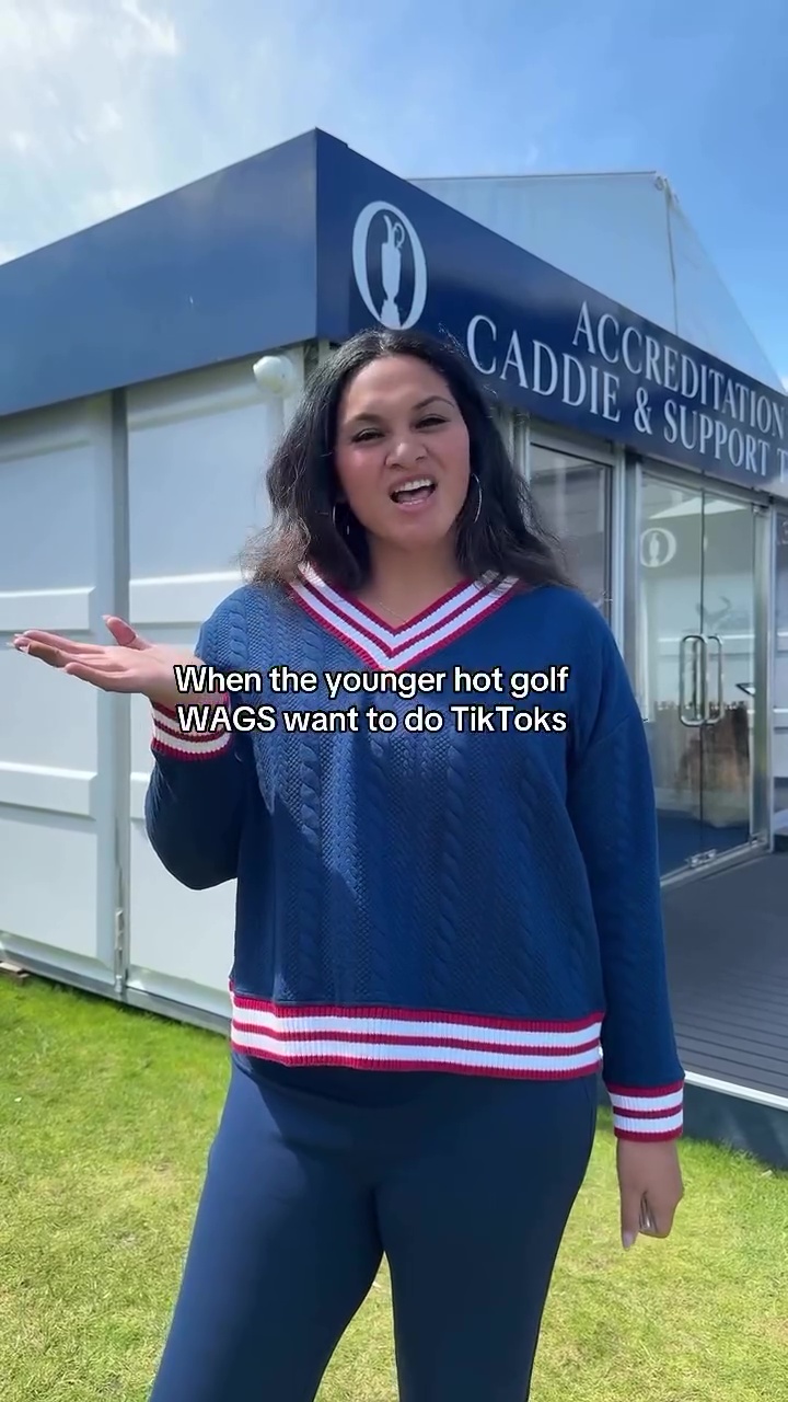 Woman in blue sweater making a TikTok video in front of a golf caddy support tent.
