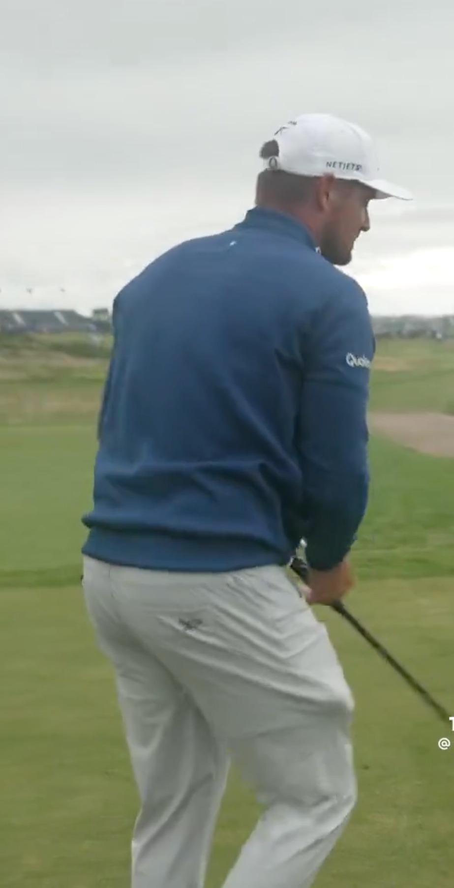Golfer walking on a golf course.