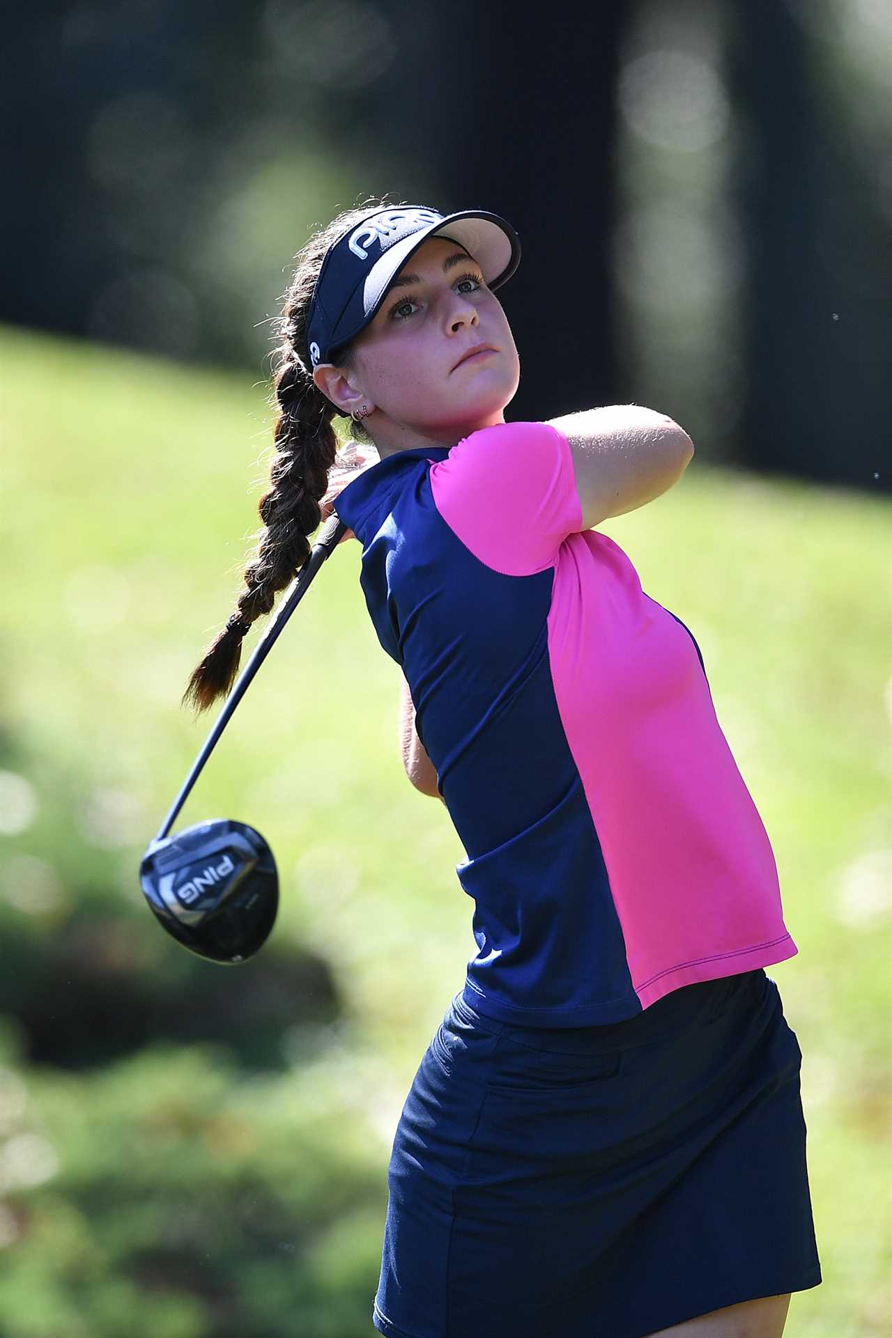 A female golfer teeing off.