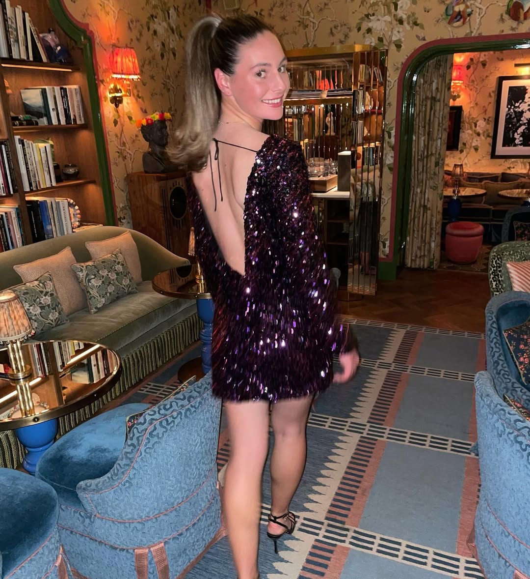 Woman in sequined dress in a luxurious room.