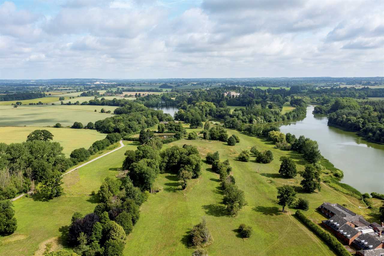 Aerial view of Patshull Park, Shropshire, featuring rolling countryside, a lake, and a hotel.