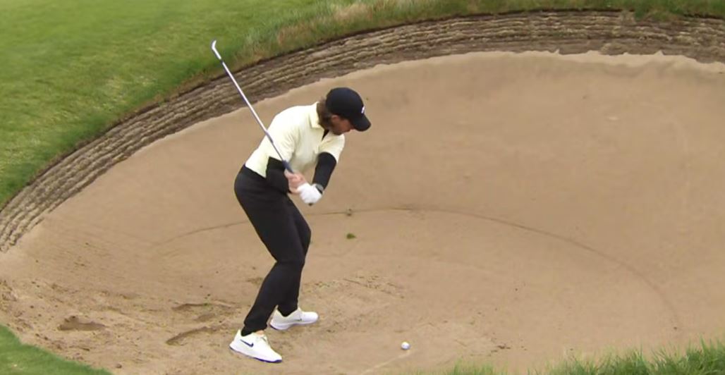 Golfer hitting a sand shot.
