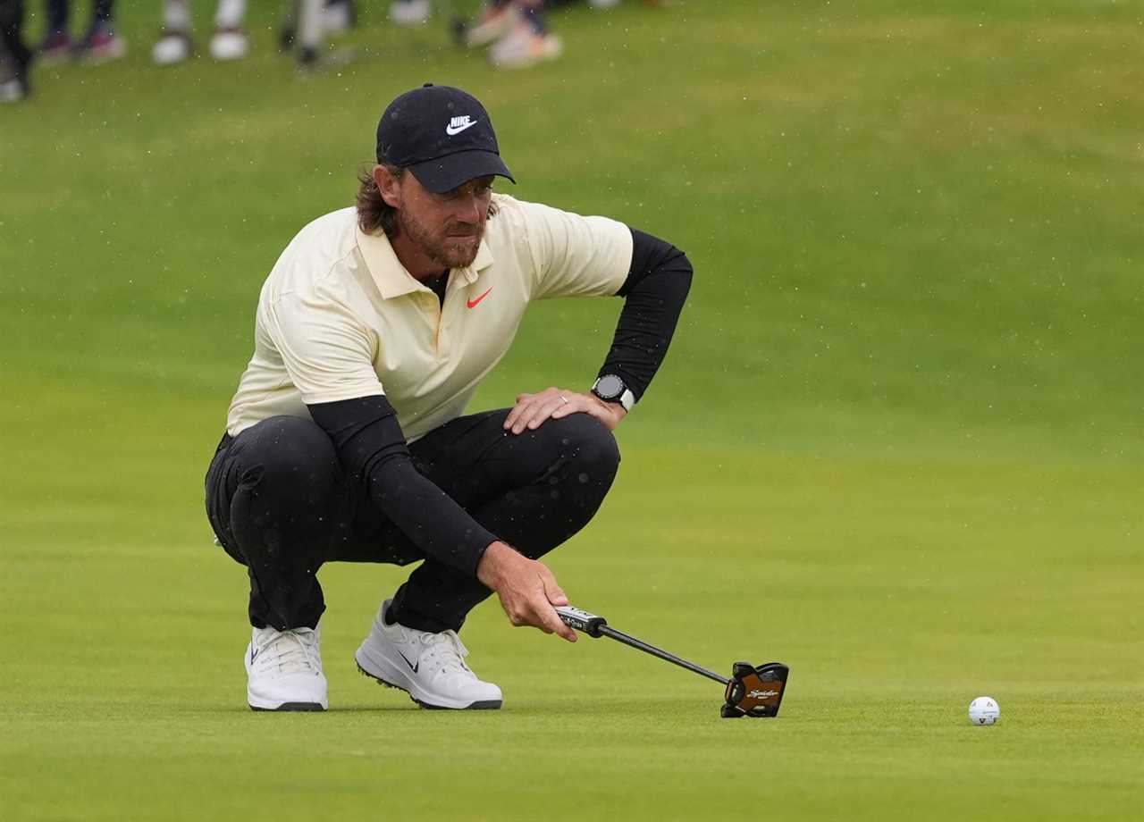 Tommy Fleetwood lining up a putt on the green.