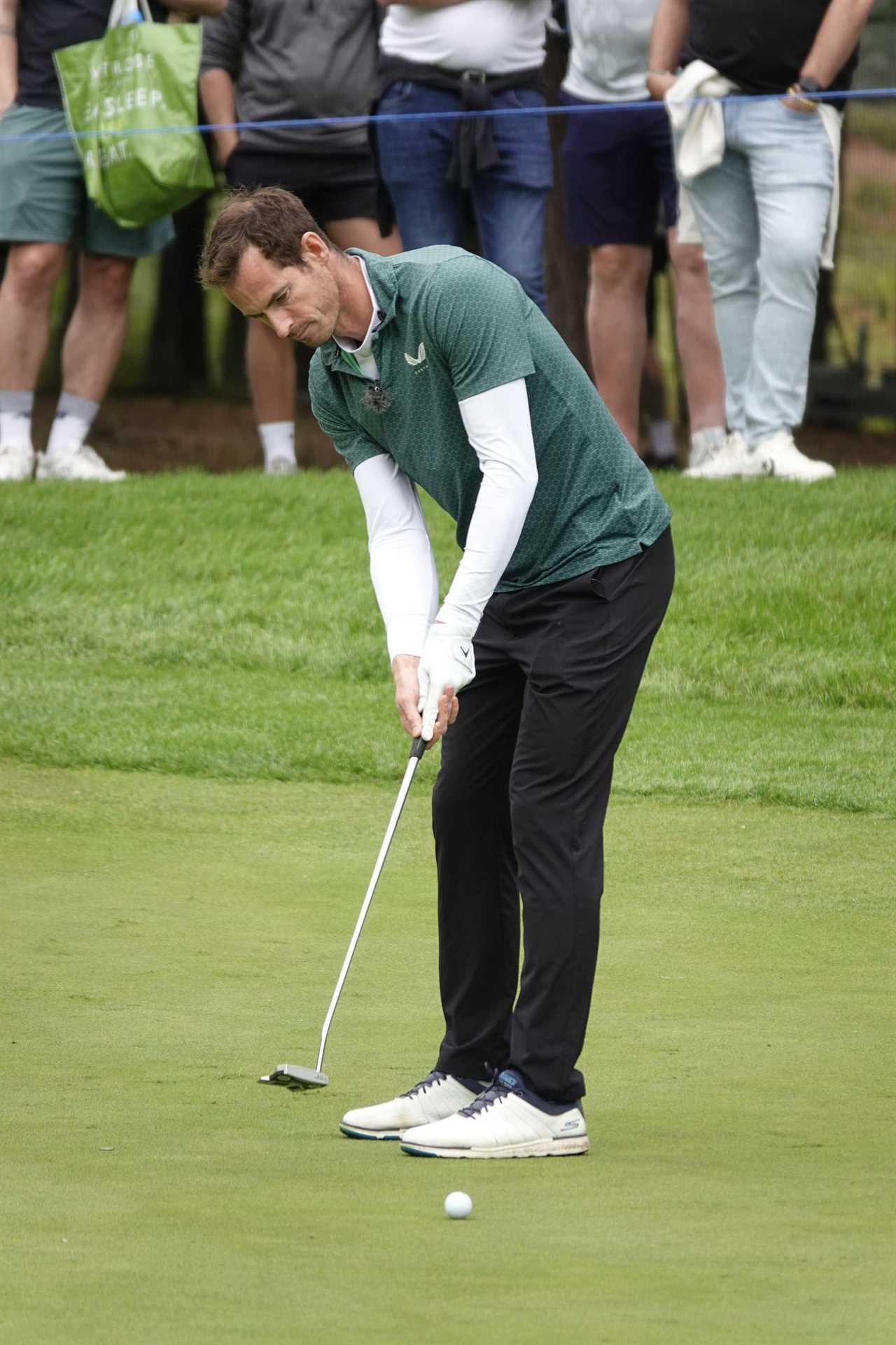 Golfer putting on a green.