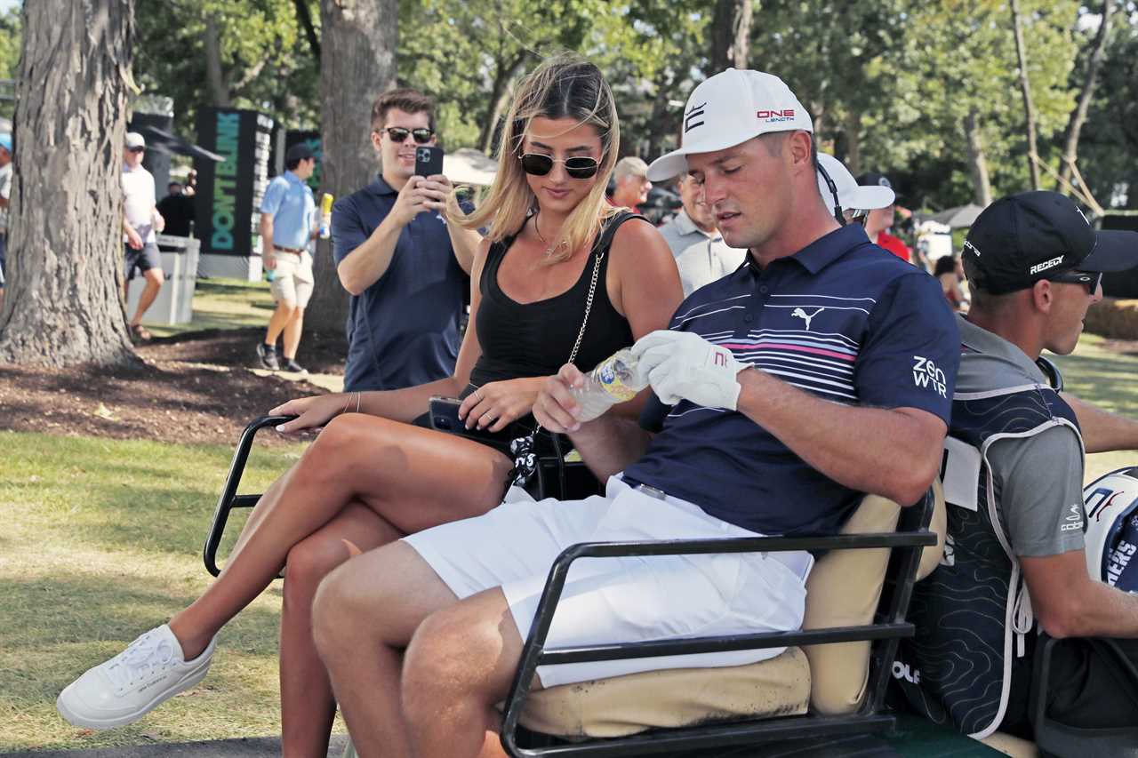 Bryson DeChambeau and his girlfriend in a golf cart.
