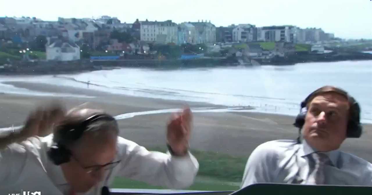 Two broadcasters react to strong winds while reporting live from the beach.