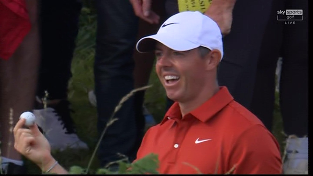 Smiling golfer holding a golf ball.