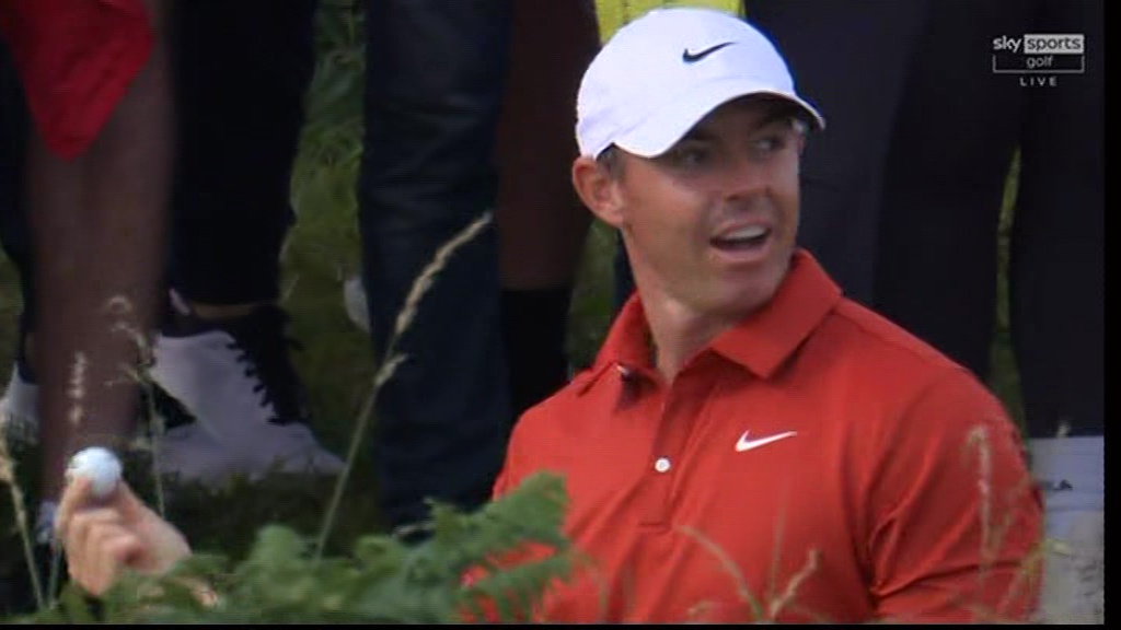 Rory McIlroy holding a golf ball.