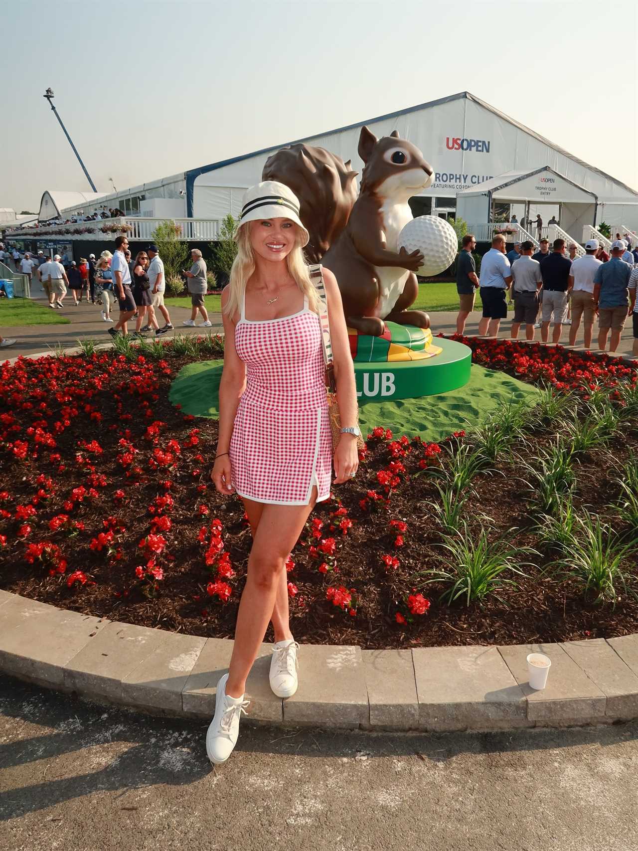Woman in red and white gingham dress at a golf tournament.