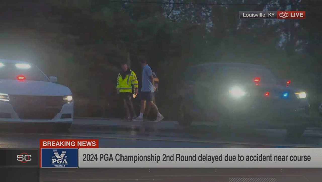 Still image from video showing Scottie Scheffler being escorted by police after an accident near Valhalla Golf Club.