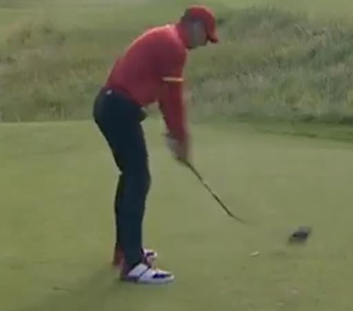 Golfer in red shirt taking a shot.
