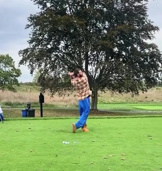 A golfer taking a swing on a golf course.