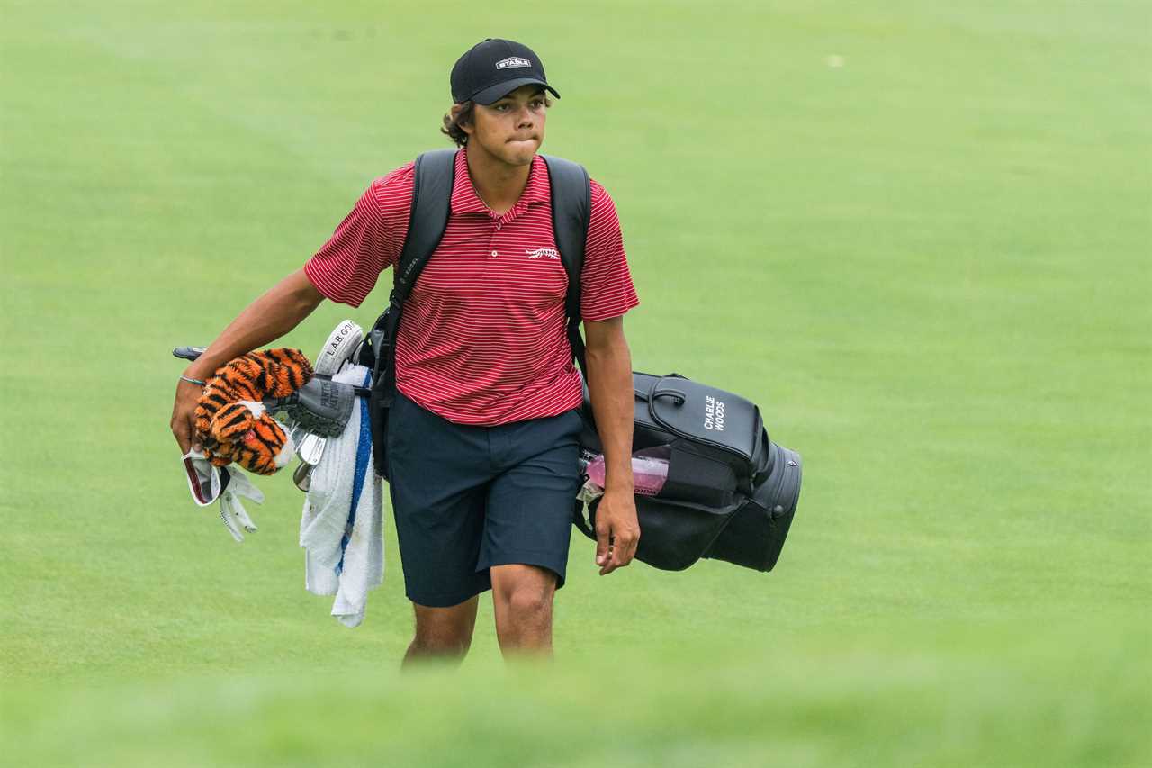 Charlie Woods walking on a golf course, carrying his golf bag.
