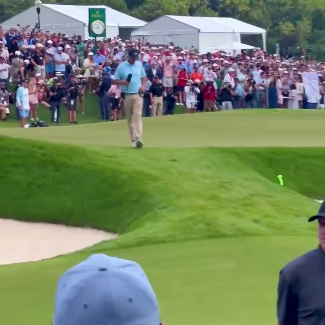 Golfer walking on the 18th green during a PGA FedEx Cup event.