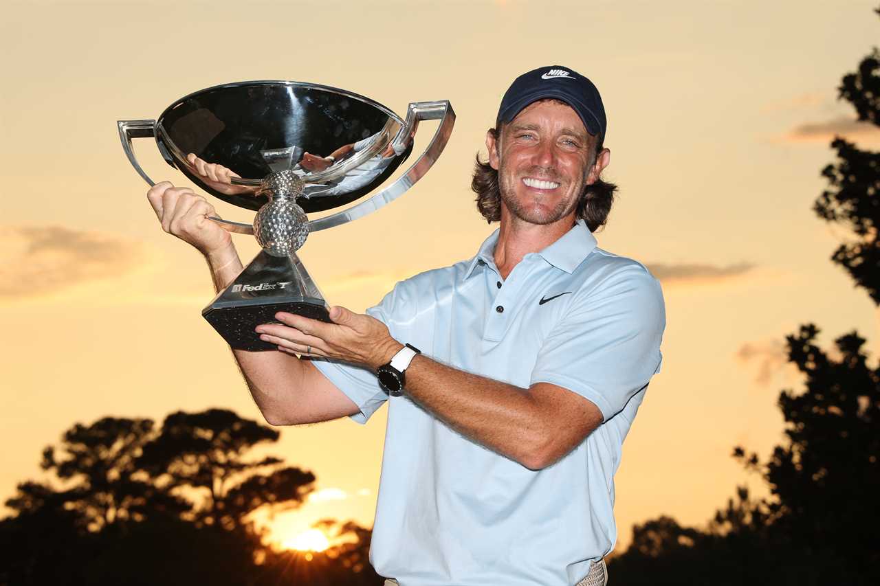 Tommy Fleetwood holding the FedEx Cup trophy.