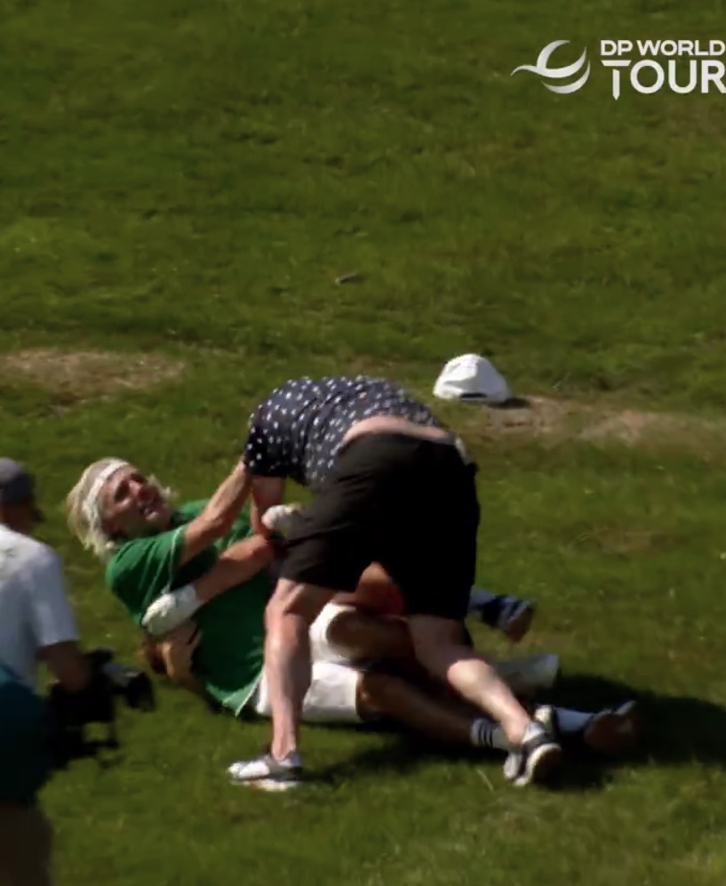 Two men wrestling on the ground.